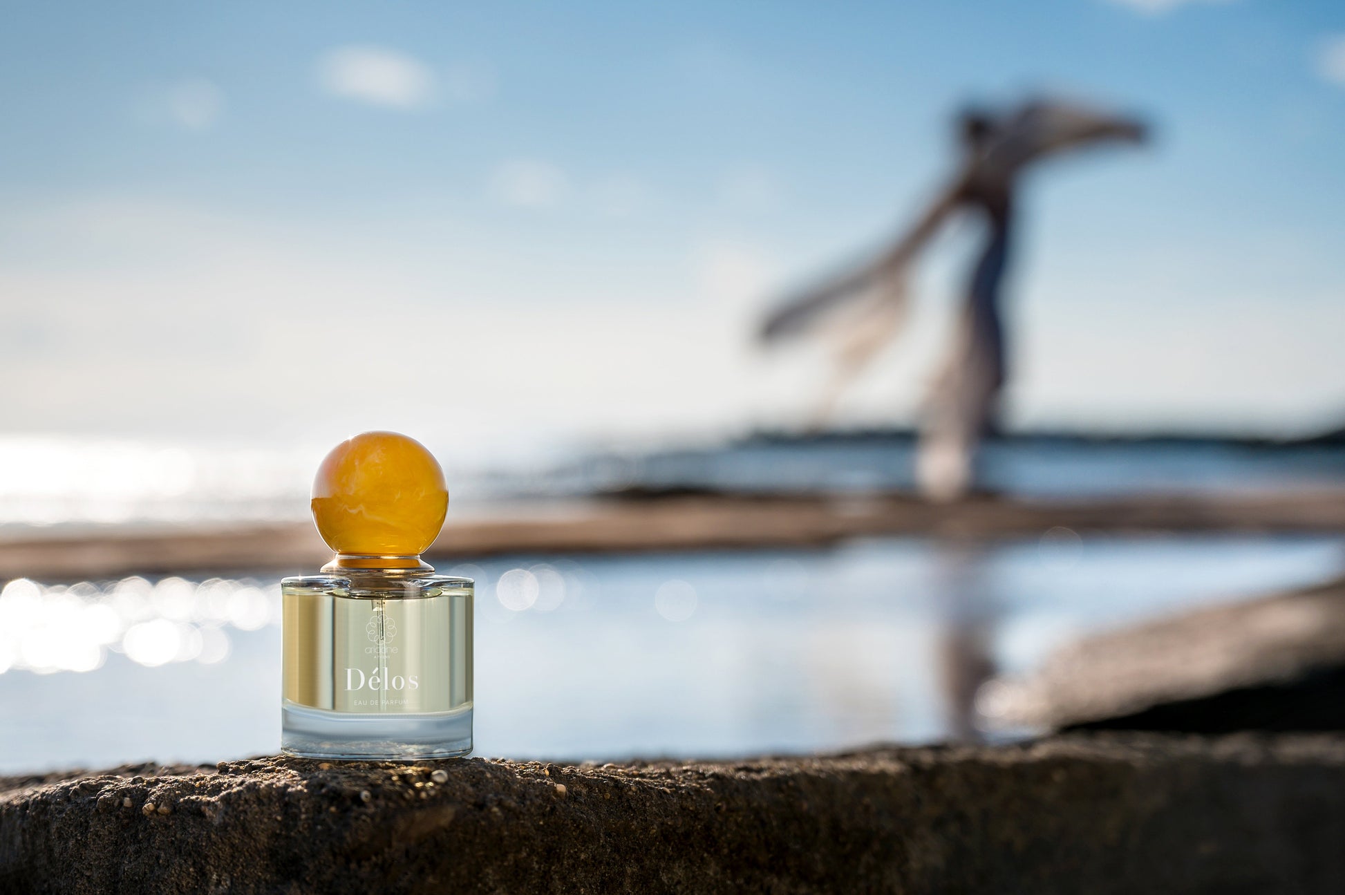 The Delos eau de parfume bottle near the sea.