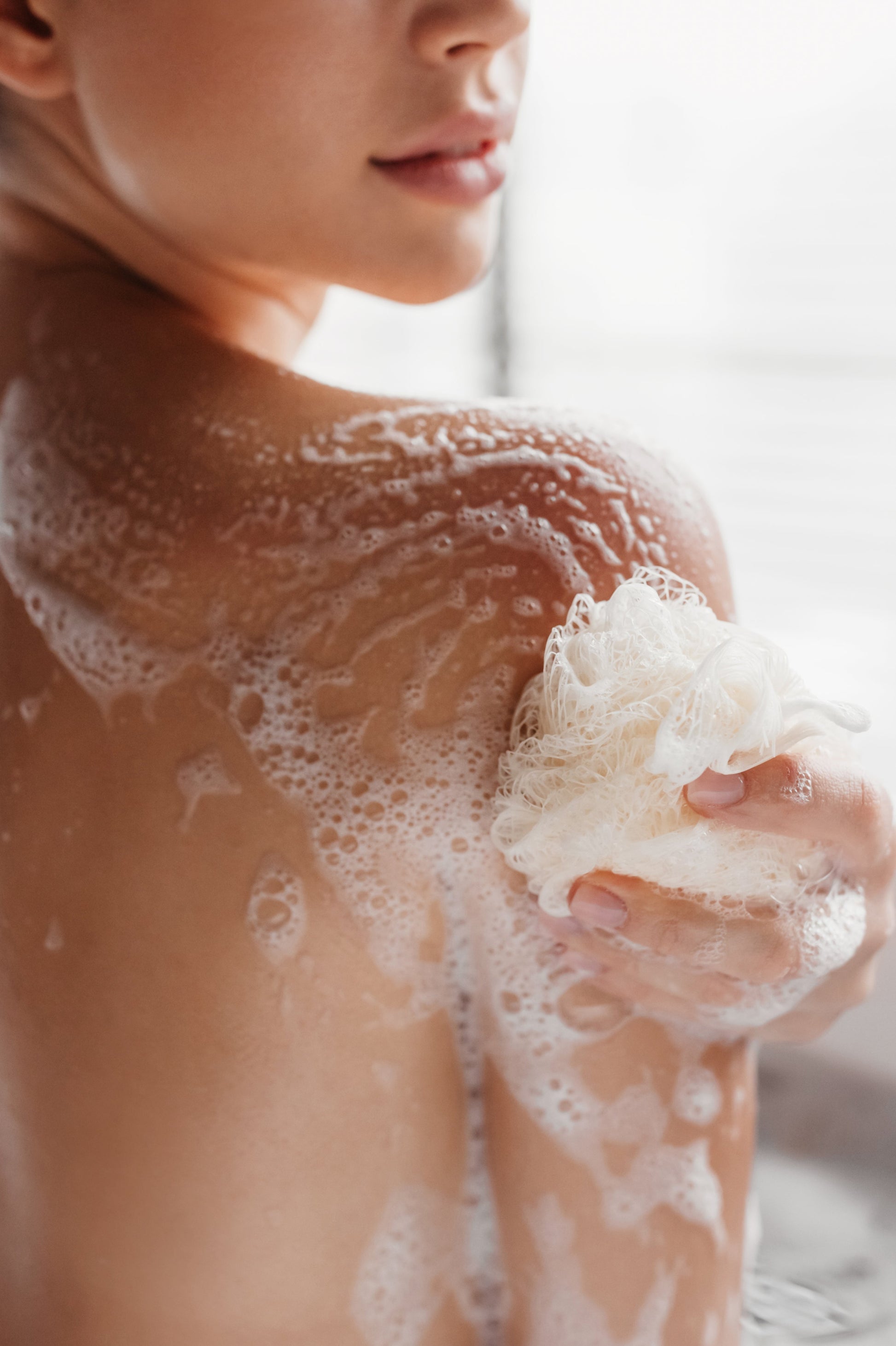 A woman applying the Narcissus Body Wash Pro.