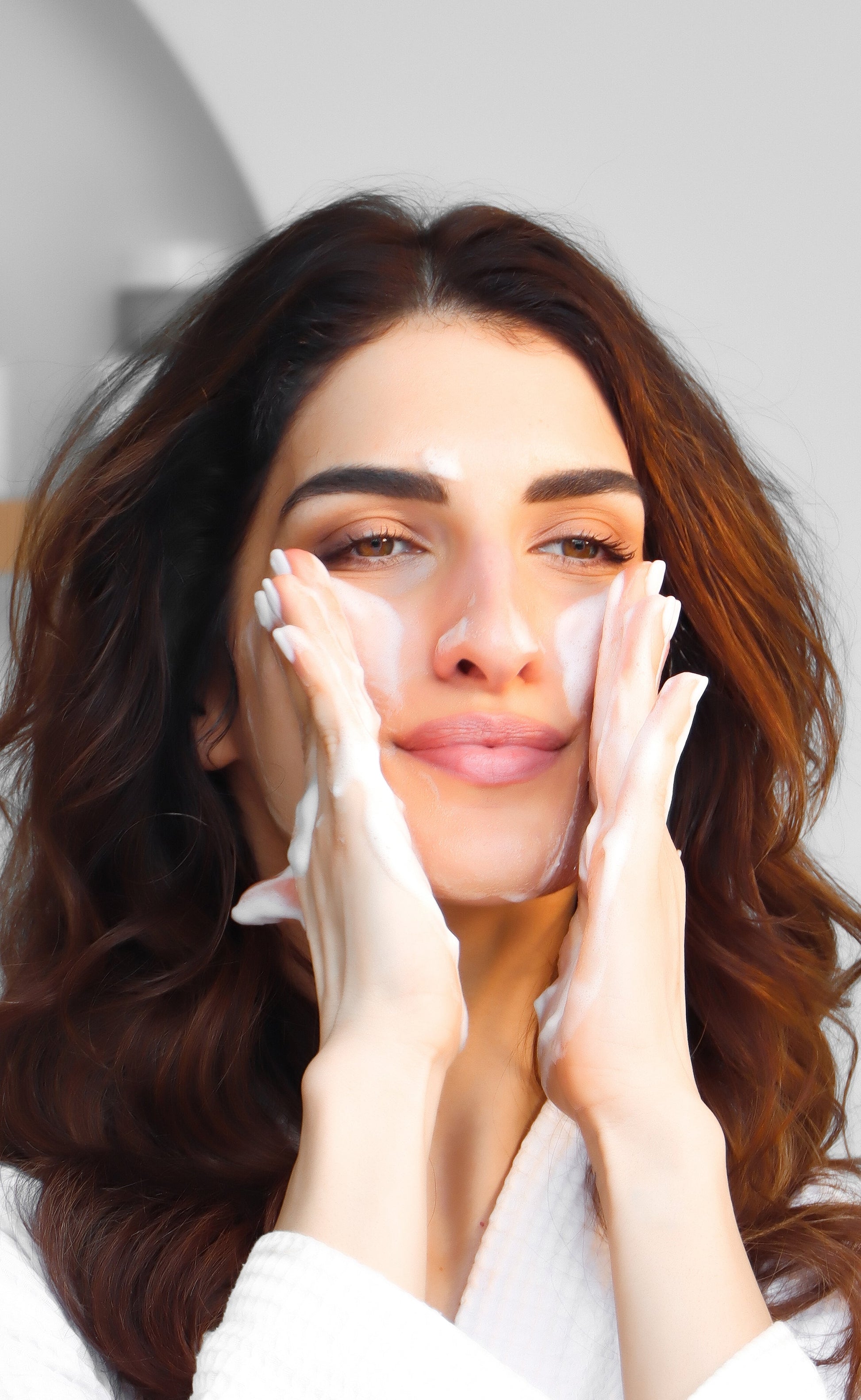 A woman cleans her face with the Foamjito Cleansing Foam Pro.
