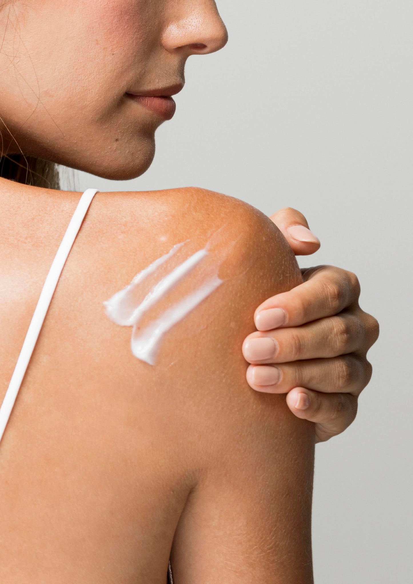A beautiful woman having Pomegranate Hand & Body Lotion on her back.