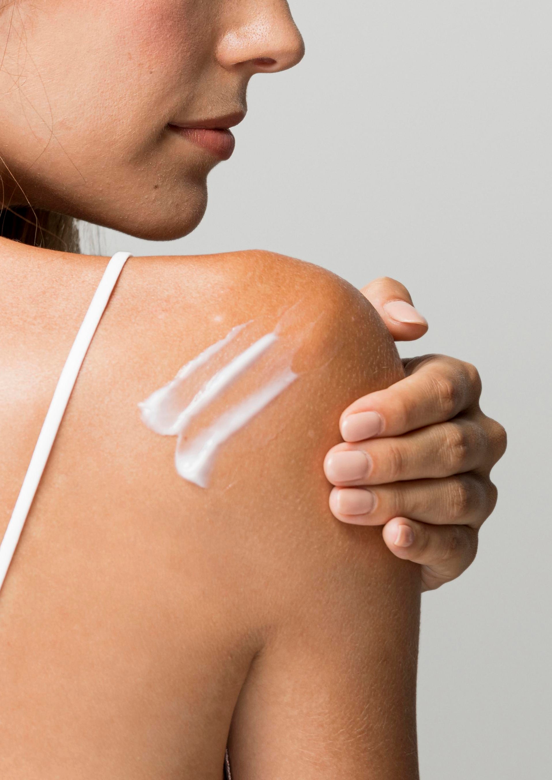 A beautiful woman having Pomegranate Hand & Body Lotion on her back.